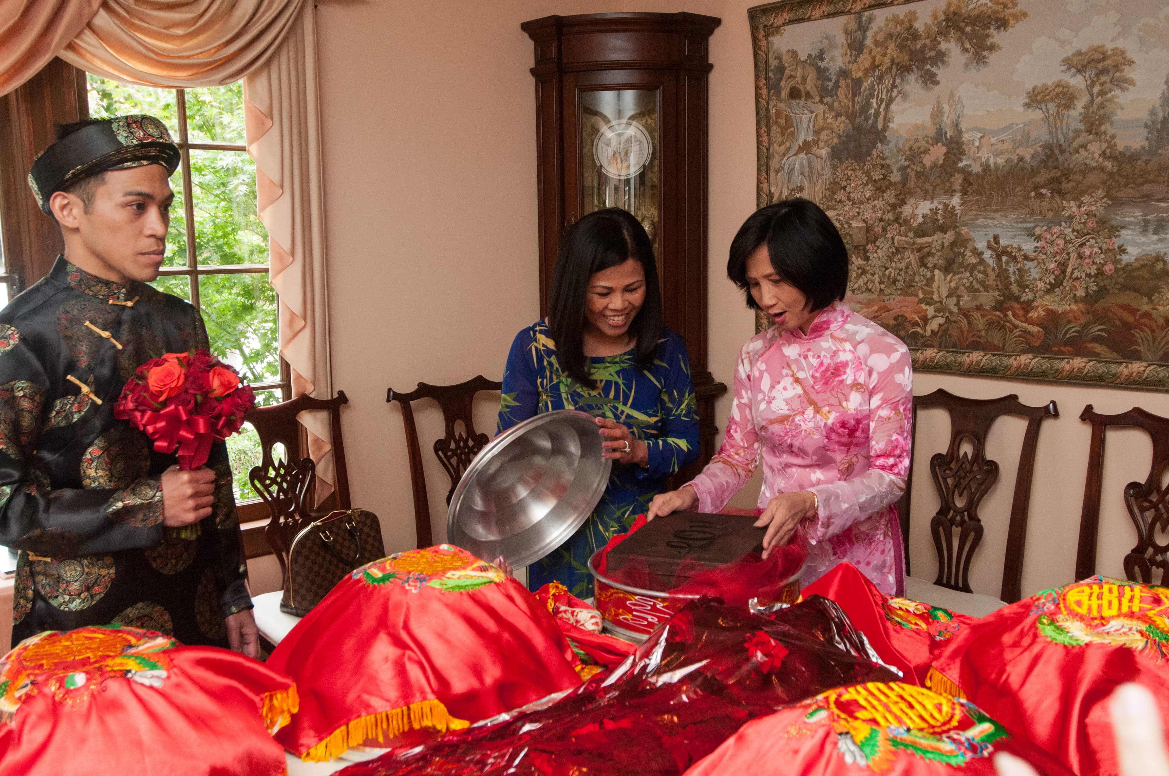 Family members unwrapping the red gift trays indoors