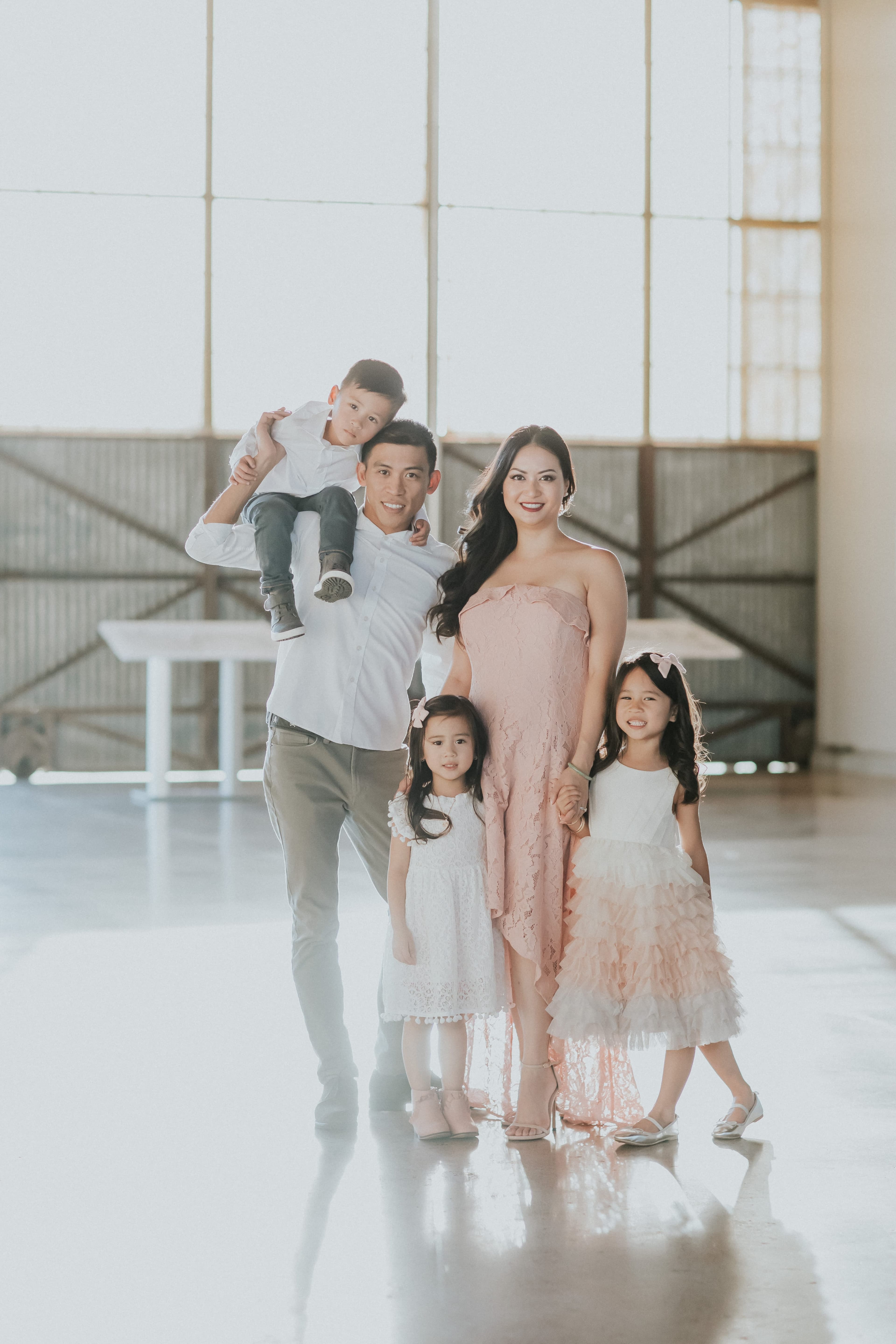 Tuan Huynh with his wife and three children in a sunlit hangar.