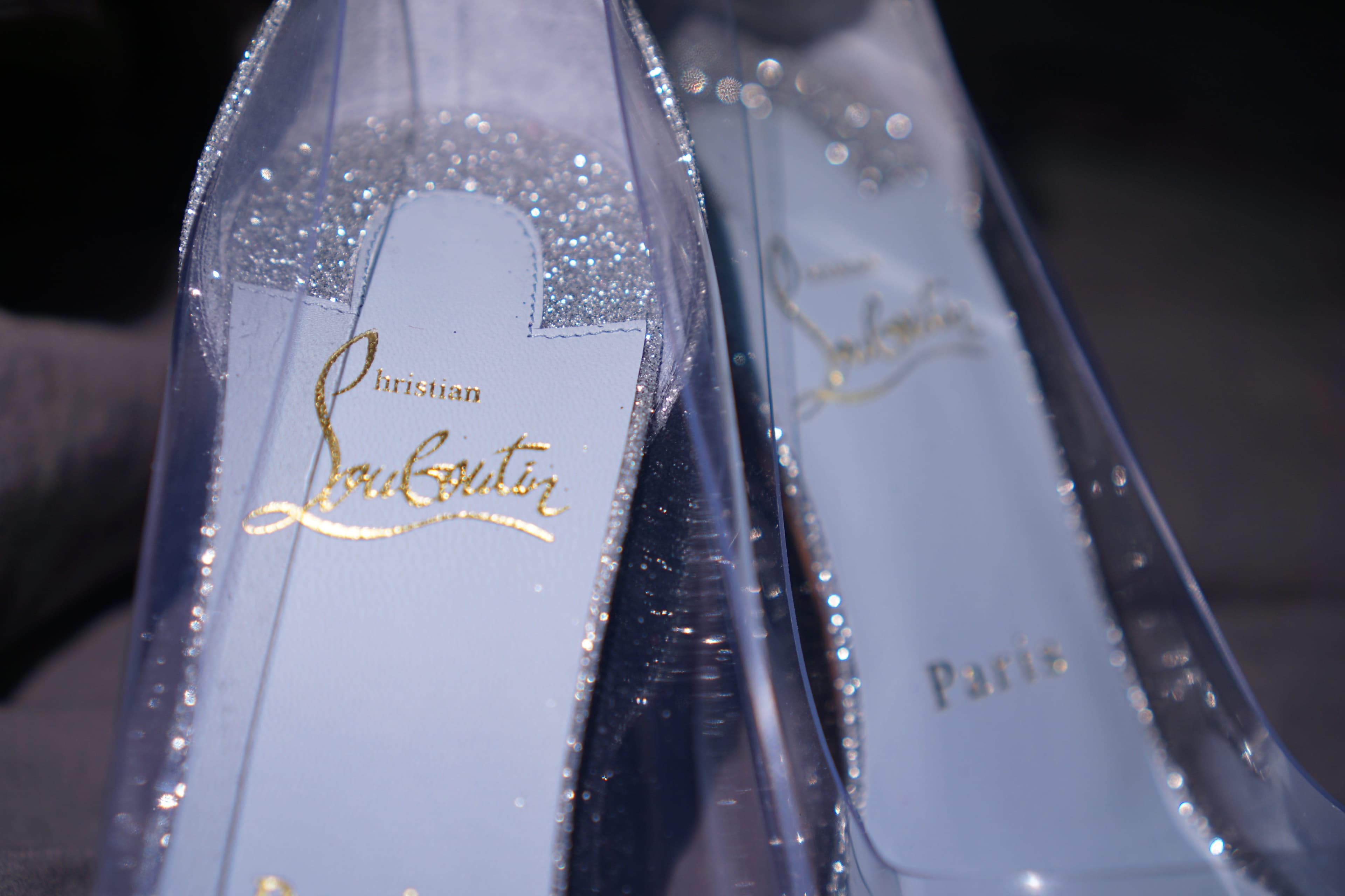 Macro shot of the gold Christian Louboutin logo stamped inside the glittered heel